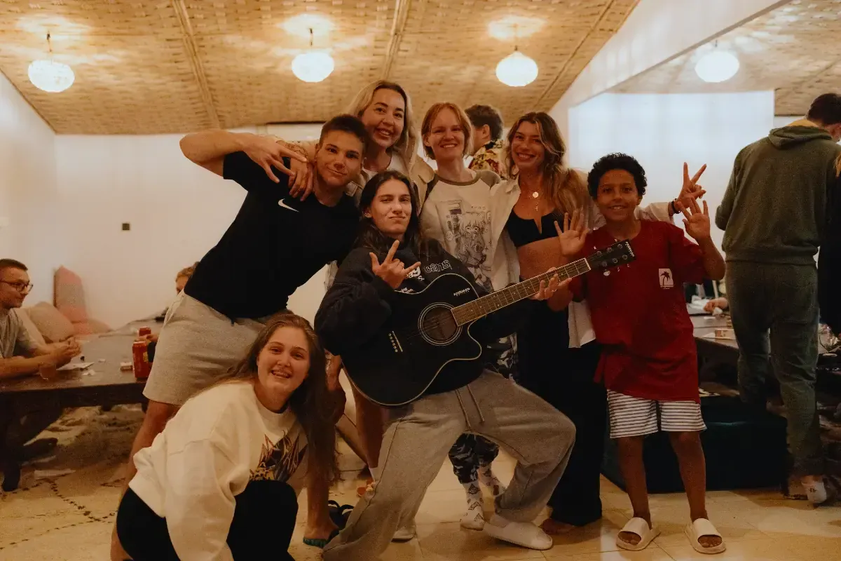 Freunde mit Gitarre im Wohnzimmer des Surfhauses Taghazout Surf Camp