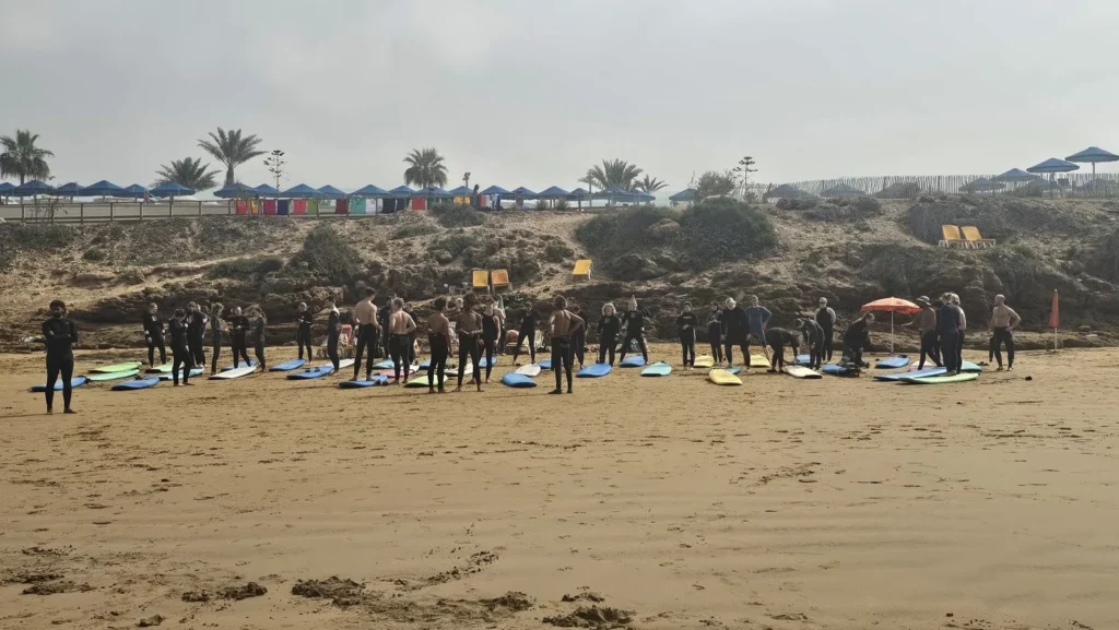 Group of surf students warming up on Crocodile Beach in Tamraght