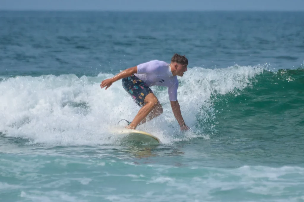 Surfschüler reitet bei einer Stunde in der Taghazout Bay, Marokko, eine Welle