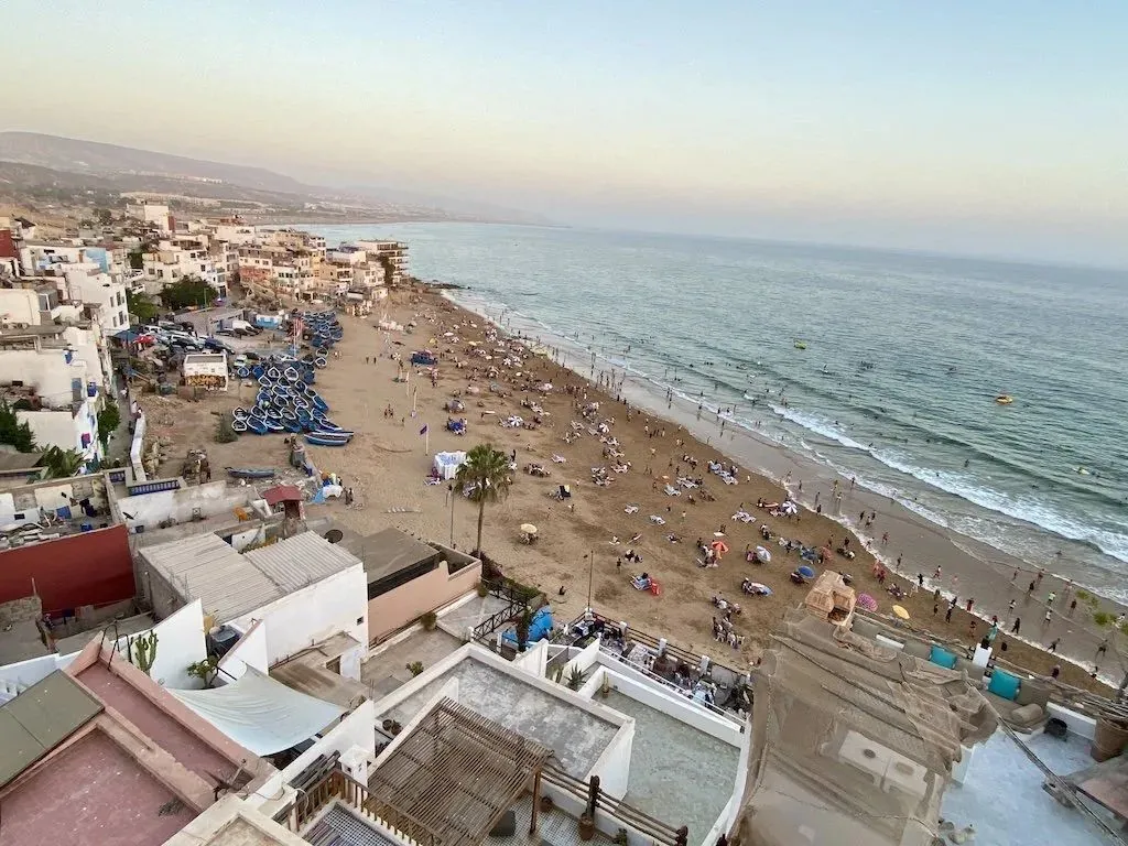 Aerial view of Taghazout village and its beach full of surfers and fishing boats