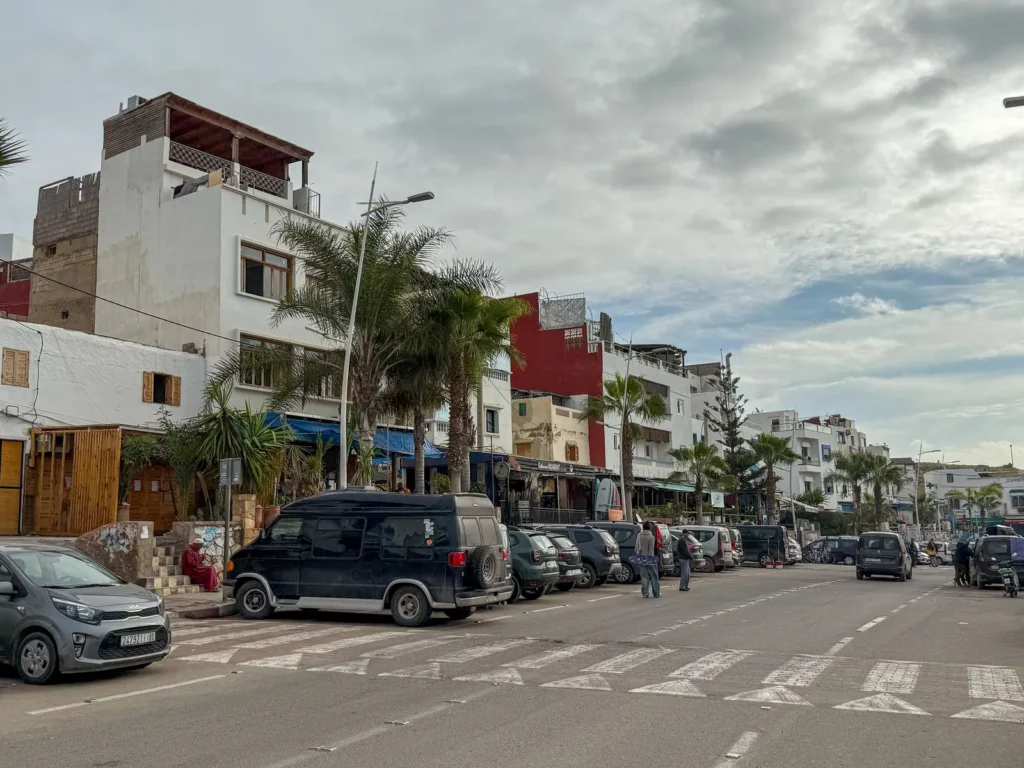 The main street of Taghazout village with colourful houses and palm trees, Morocco